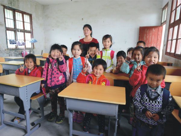 公司為一山村小學捐贈一批課桌椅，孩子們高興地和老師一起合影